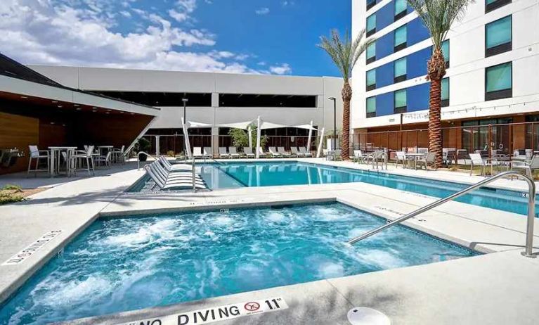 beautiful outdoor pool with seating and sun beds at Home2 Suites by Hilton Las Vegas Convention Center.