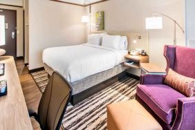 Desk, sofa and king size bed in a king bedroom at the Hilton Garden Inn Minneapolis Airport Mall of America.