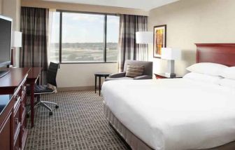 Bright and comfoertable king bedroom with window at the DoubleTree by Hilton Kansas City - Overland Park.