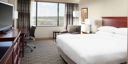 Bright and comfoertable king bedroom with window at the DoubleTree by Hilton Kansas City - Overland Park.