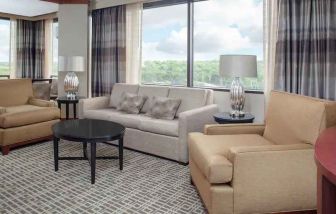 Living area with working station in a hotel suite at the DoubleTree by Hilton Kansas City - Overland Park.