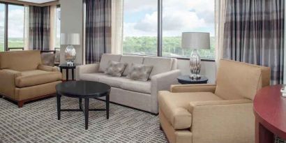 Living area with working station in a hotel suite at the DoubleTree by Hilton Kansas City - Overland Park.