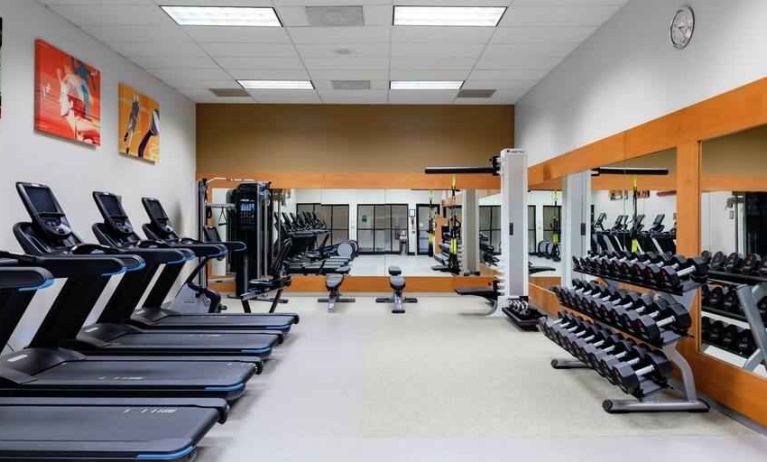 Fitness center with treadmills and weights at the DoubleTree by Hilton Kansas City - Overland Park.