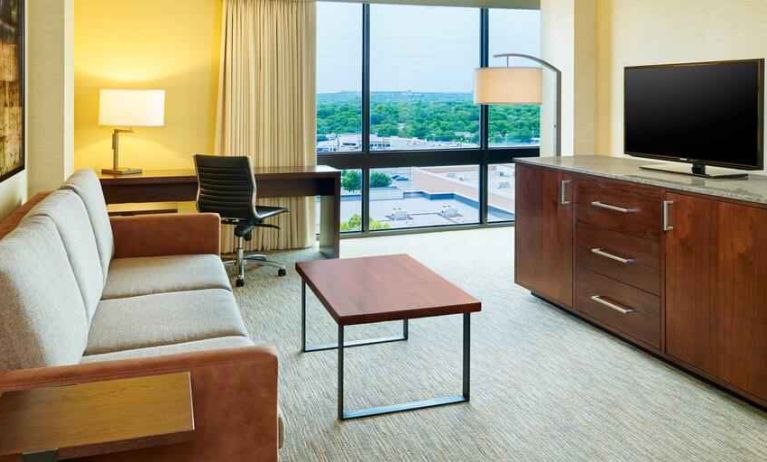 Living area with sofa and desk in a king suite at the Hilton San Antonio-Airport.