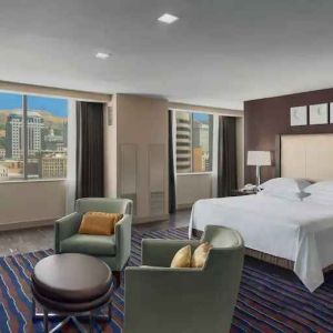 Spacious bedroom with king size bed in a hotel suite at the Hilton Salt Lake City Center.