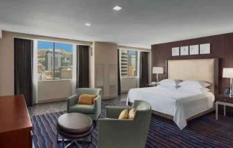 Spacious bedroom with king size bed in a hotel suite at the Hilton Salt Lake City Center.