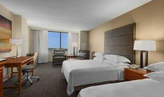 Bright double queen room with window and desk at the Hilton Salt Lake City Center.