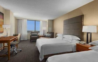 Bright double queen room with window and desk at the Hilton Salt Lake City Center.