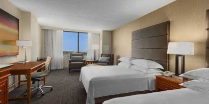 Bright double queen room with window and desk at the Hilton Salt Lake City Center.