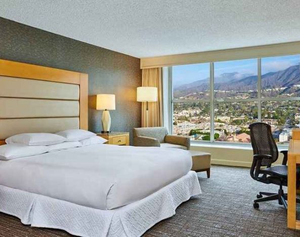 spacious king suite with natural light and work desk at Hilton Los Angeles North/Glendale & Executive Meeting Ctr.