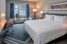 comfortable king bedroom with city views and natural light at Hilton Garden Inn Austin University.