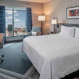 Comfortable king bedroom with city views and natural light at Hilton Garden Inn Austin University.