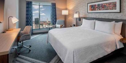 comfortable king bedroom with city views and natural light at Hilton Garden Inn Austin University.