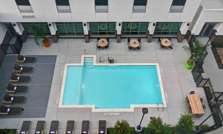 Outdoor pool area with lounges at the Home2 Suites by Hilton Houston Medical Center.