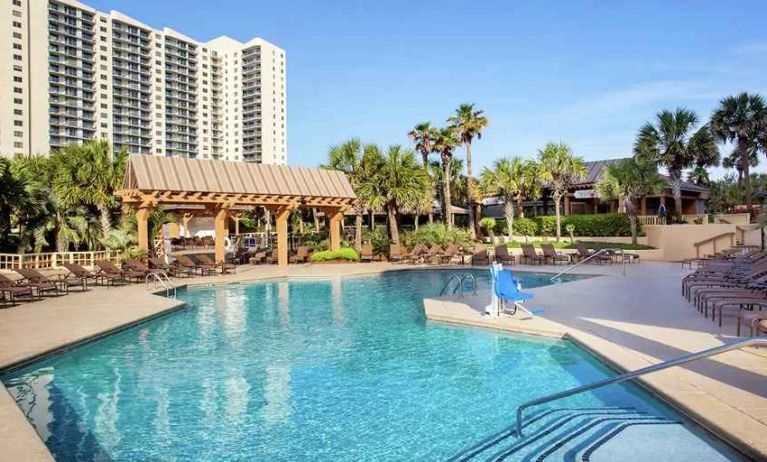 stunning outdoor pool with sun beds and outdoor seating at Kingston Plantation Condos.