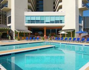 lovely outdoor pool with seating area and sun beds at Hilton Myrtle Beach Resort.