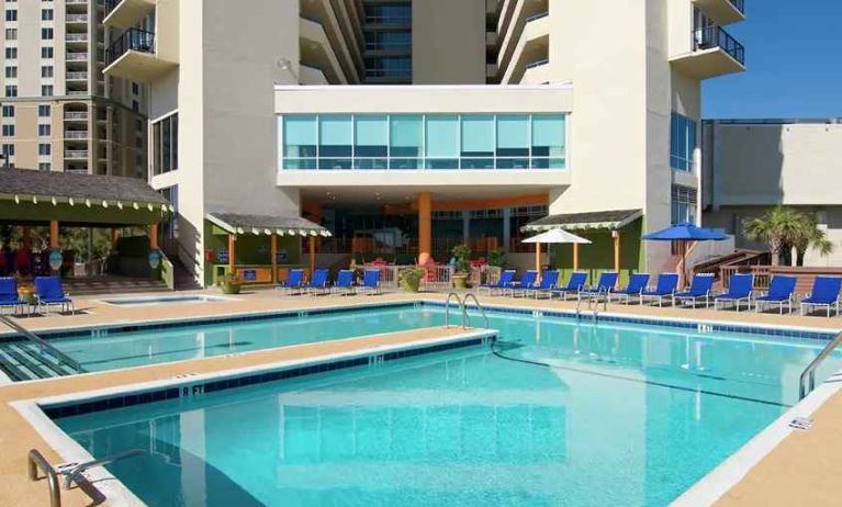 lovely outdoor pool with seating area and sun beds at Hilton Myrtle Beach Resort.