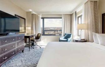 beautiful king room with work desk, TV, and natural light at Washington Hilton.