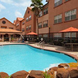 beautiful outdoor pool with sun beds and seating area at Homewood Suites by Hilton Houston-Woodlands.