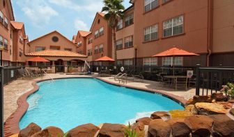 beautiful outdoor pool with sun beds and seating area at Homewood Suites by Hilton Houston-Woodlands.