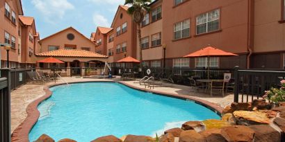 beautiful outdoor pool with sun beds and seating area at Homewood Suites by Hilton Houston-Woodlands.