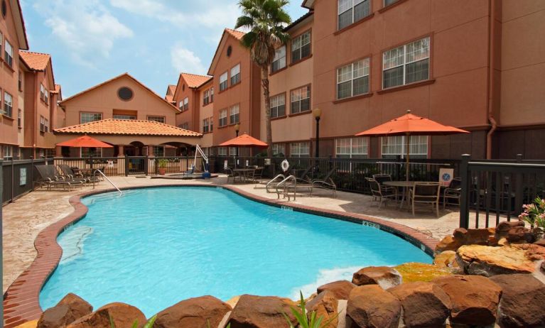 beautiful outdoor pool with sun beds and seating area at Homewood Suites by Hilton Houston-Woodlands.