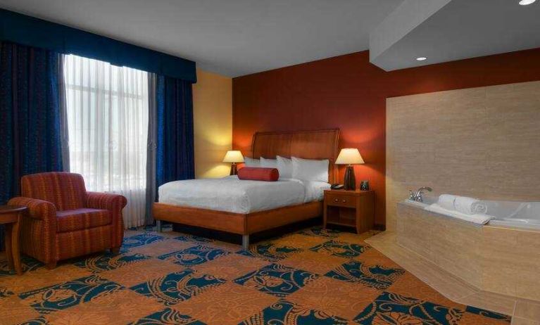 Comfortable king guestroom with window and whirlpool at the Hilton Garden Inn Fort Worth Medical Center.