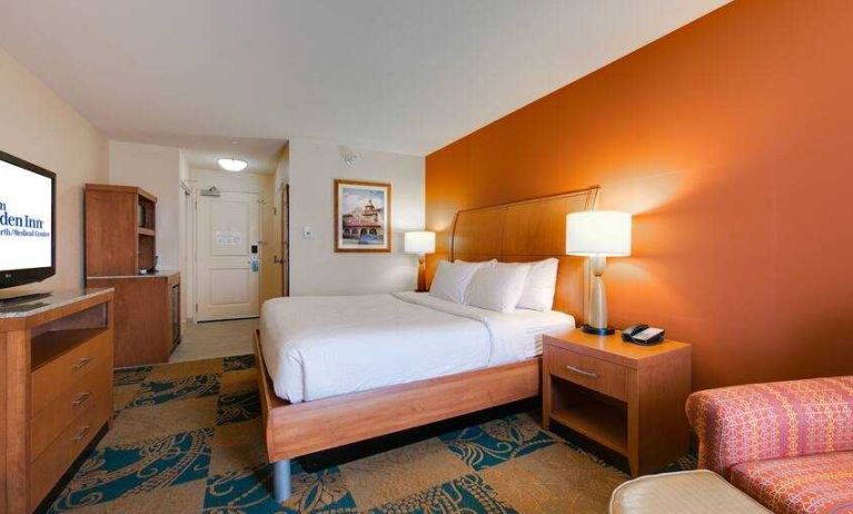 King size bed, TV screen and sofa in a king bedroom at the Hilton Garden Inn Fort Worth Medical Center.