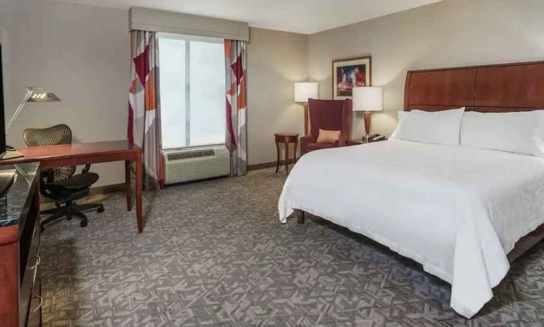 King size bed and desk in a hotel bedroom at the Hilton Garden Inn Blacksburg University.