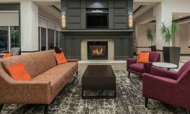 Comfortable workspace by the fireplace in a hotel lobby at the Hilton Garden Inn Blacksburg University.