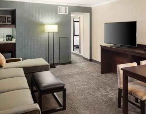 Spacious and comfortable hotel living room with sofa and desk at the Embassy Suites by Hilton Tysons Corner.