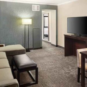 Spacious and comfortable hotel living room with sofa and desk at the Embassy Suites by Hilton Tysons Corner.