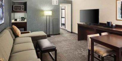 Spacious and comfortable hotel living room with sofa and desk at the Embassy Suites by Hilton Tysons Corner.