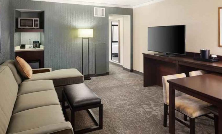 Spacious and comfortable hotel living room with sofa and desk at the Embassy Suites by Hilton Tysons Corner.