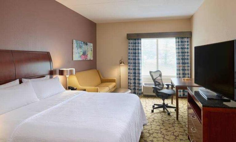 King bedroom with TV screen, sofa and desk at the Hilton Garden Inn Hershey.