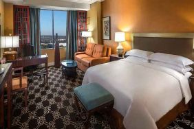 beautiful king room with natural light, TV, and work desk at Hilton Anatole.