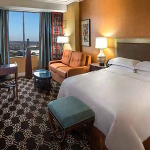 beautiful king room with natural light, TV, and work desk at Hilton Anatole.