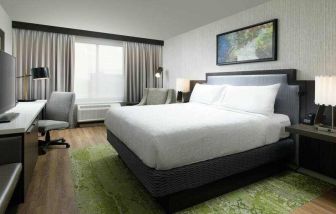 King bedroom with TV screen, desk and window at the Hilton Garden Inn Memphis Downtown.