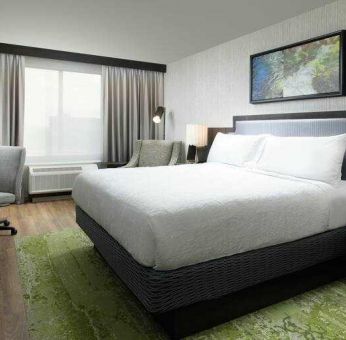 King bedroom with TV screen, desk and window at the Hilton Garden Inn Memphis Downtown.