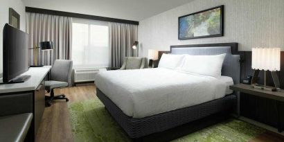 King bedroom with TV screen, desk and window at the Hilton Garden Inn Memphis Downtown.