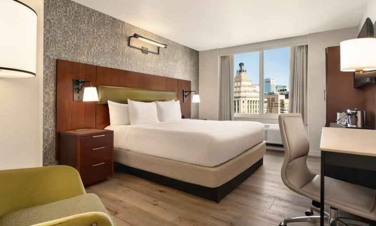 King bedroom with desk and city view at the DoubleTree by Hilton New York Downtown.