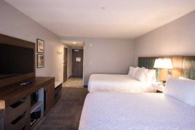 Double queen bedroom with TV screen at the Hampton Inn & Suites North Attleboro.