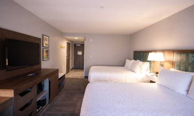 Double queen bedroom with TV screen at the Hampton Inn & Suites North Attleboro.