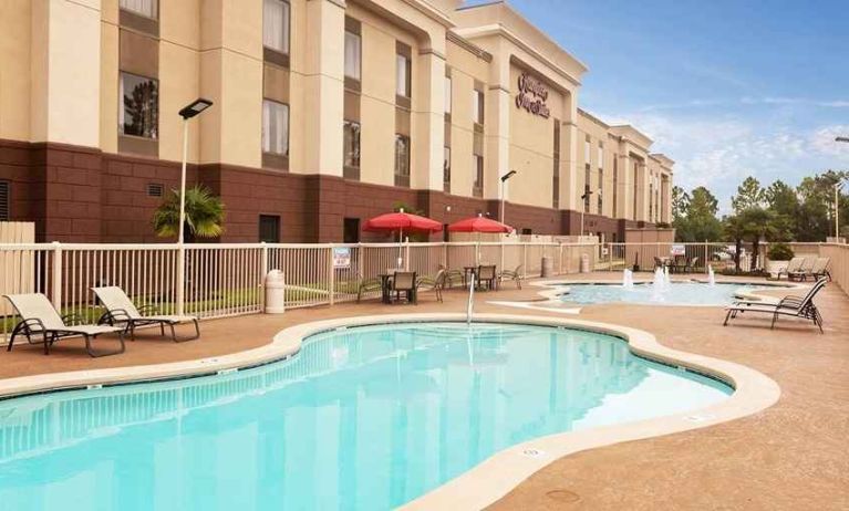 beautiful outdoor pool with sun beds and seating at Hampton Inn & Suites Baton Rouge - I-10 East.