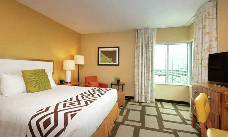 luxurious king suite with TV, work area, and lounge at Embassy Suites by Hilton Houston Downtown.