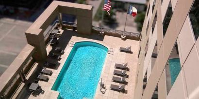 gorgeous outdoor pool with sunbeds and seating at Hampton Inn Houston Downtown.