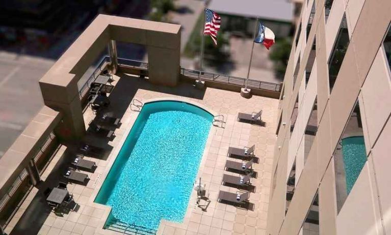 gorgeous outdoor pool with sunbeds and seating at Homewood Suites by Hilton Houston Downtown.