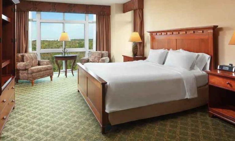 Bright king suite with window and sofas at the Embassy Suites by Hilton Charleston Airport Convention Center.