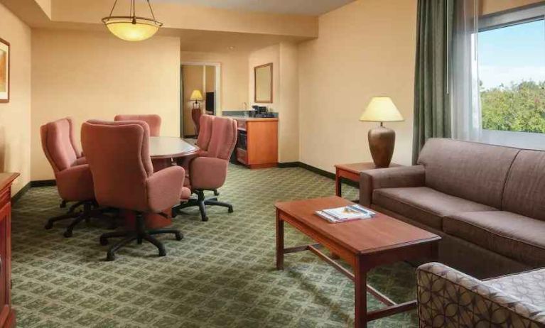 Spacious living room with working station in a hotel suite at the Embassy Suites by Hilton Charleston Airport Convention Center.