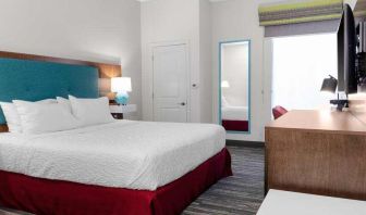 King bedroom with TV screen and window at the Hampton Inn Concord Bow.